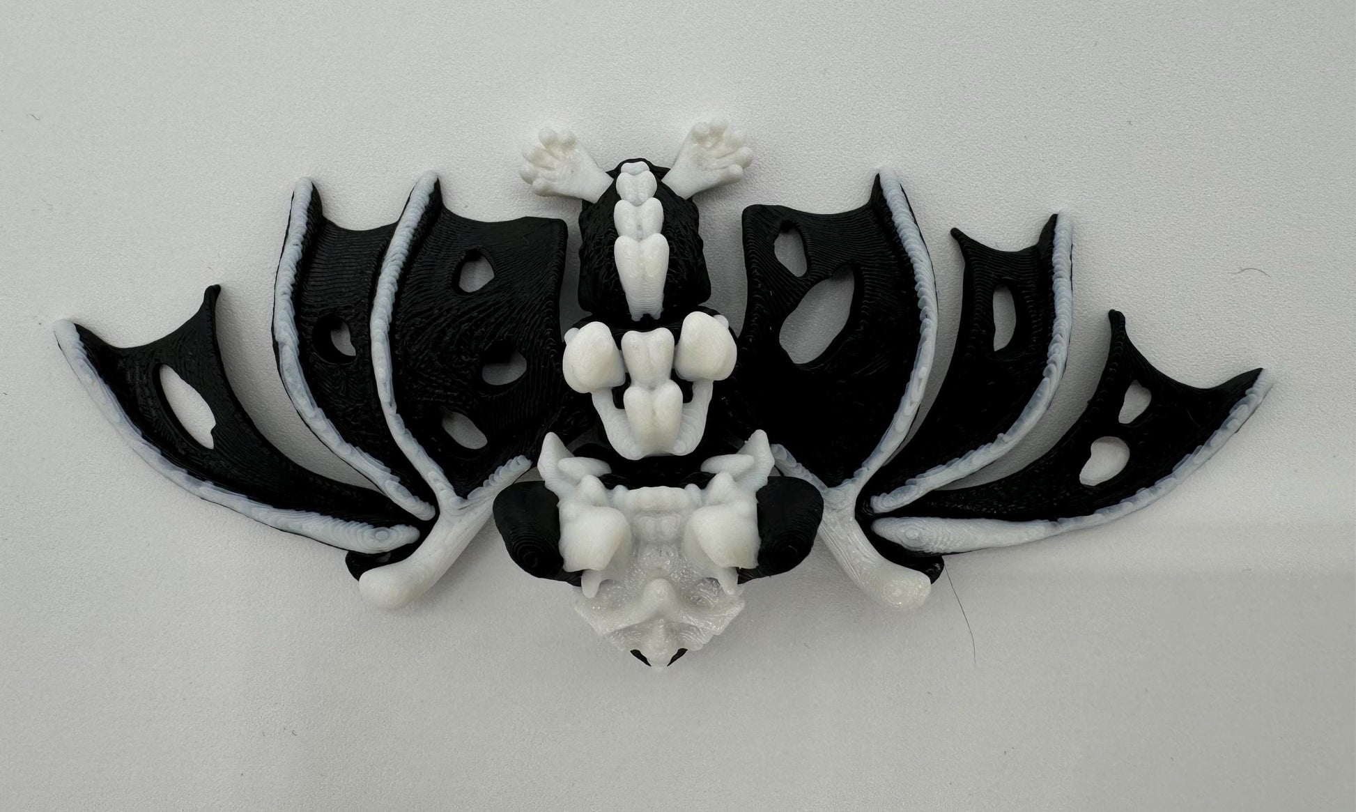 Articulating fidget “hollow bat” toy